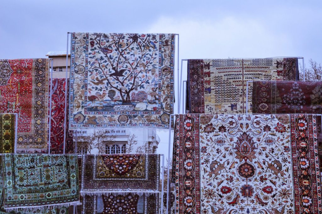 a bunch of rugs that are hanging up