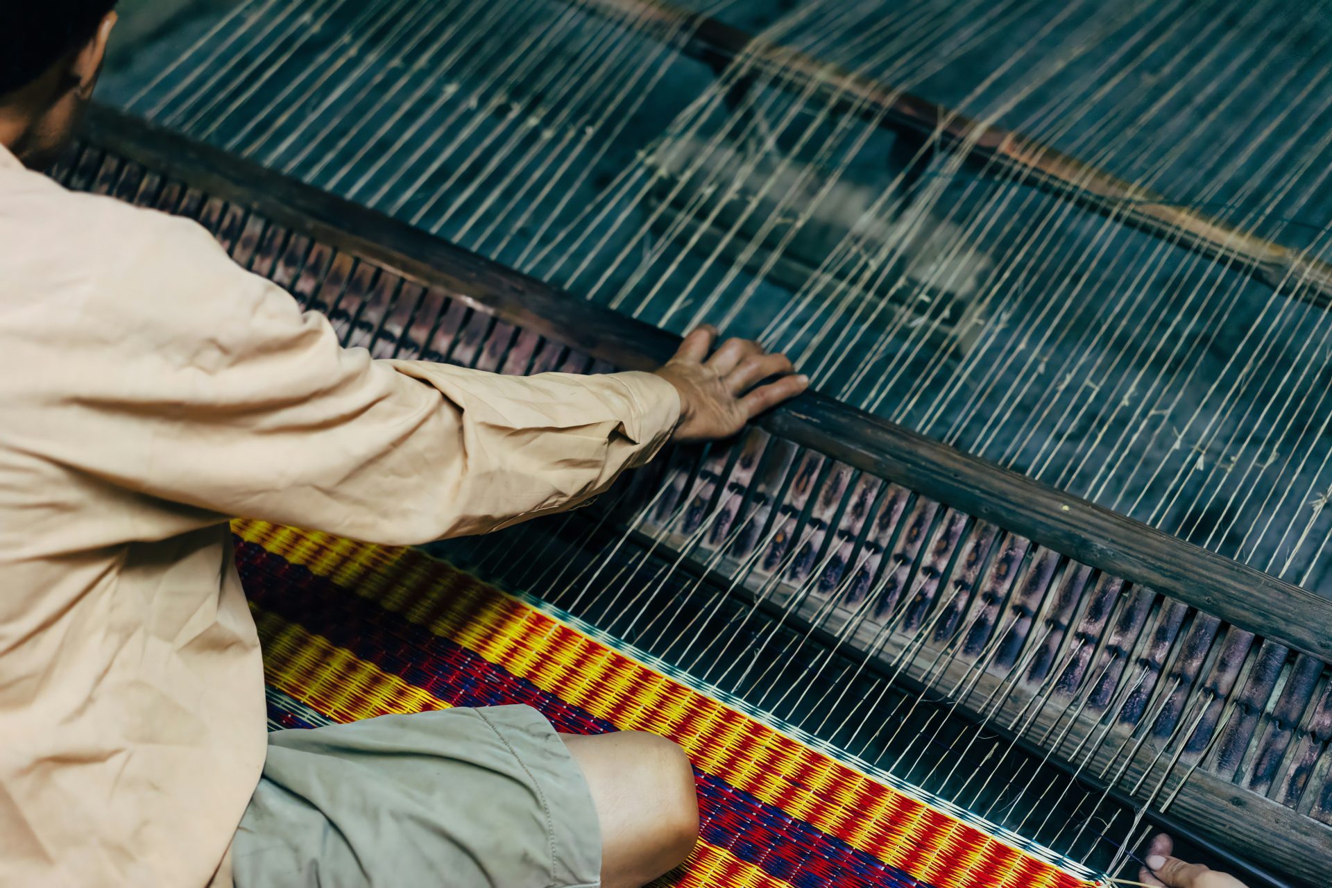 a man is weaving fabric on a loom